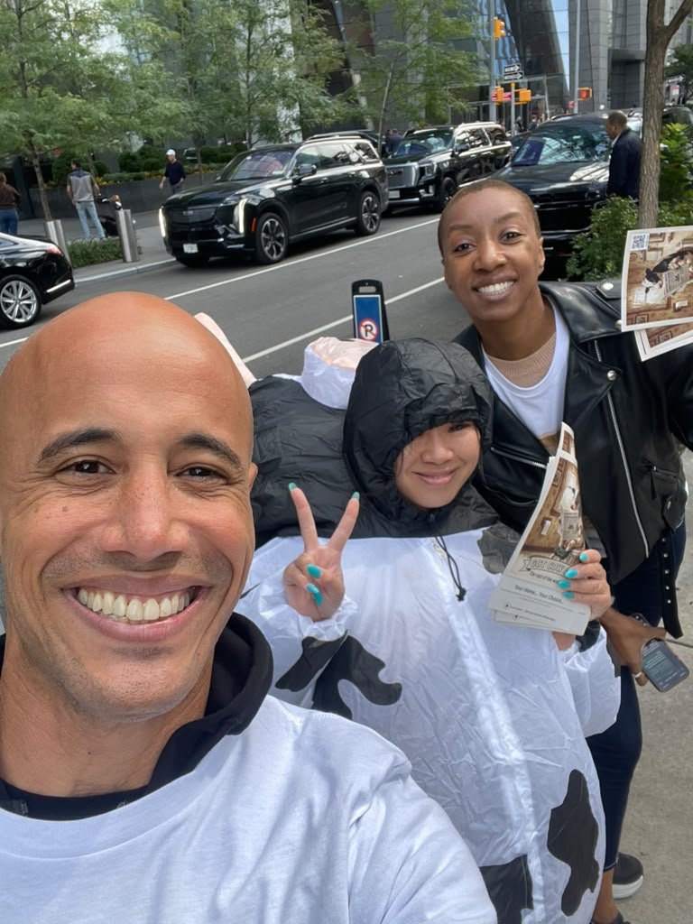 Andrew Lauter with the Got Cow Gas street team, one in a cow costume, handing out flyers in Manhattan